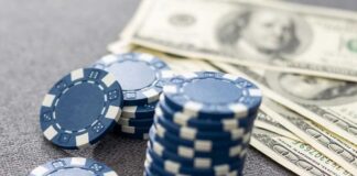Stack of blue poker chips next to cash bills