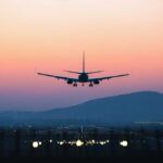 Drone Panic Over NYC An airplane approaching for landing against a colorful sunset sky