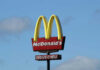 Vintage McDonald’s Treat Stages Comeback McDonalds drive-thru sign against a blue sky.