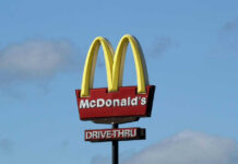 Vintage McDonald’s Treat Stages Comeback McDonalds drive-thru sign against a blue sky.