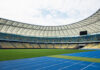 Empty stadium with blue running track and green field