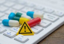 Pills and warning sign on a computer keyboard
