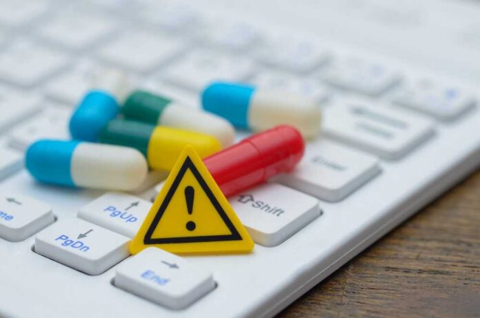 Pills and warning sign on a computer keyboard